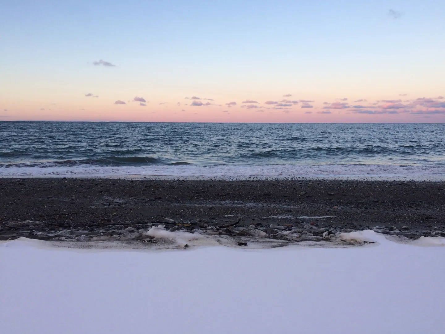 Plage au crépuscule, ciel dégradé du bleu au rose au-dessus de la mer
